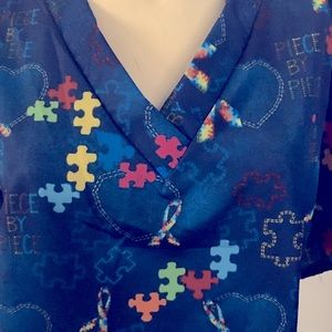 Navy blue scrub top with colorful puzzles , ribbons , and hearts